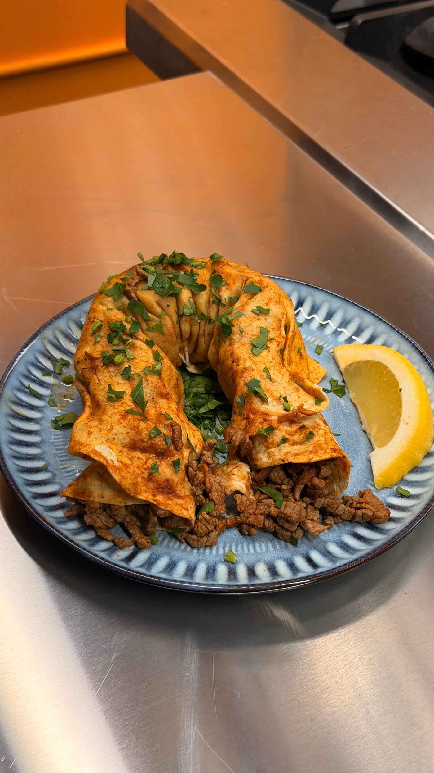 Tantuni wrap with seasoned filling, herbs and lemon